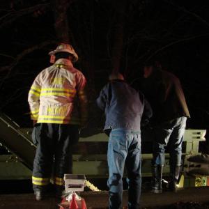 Wiscasset Fire Chief T.J. Merry, left, an unknown man and Alna Assistant Fire Chief Roger Whitney look down to where fellow rescuers were returning down a banking and into the water. SUSAN JOHNS/Wiscasset Newspaper