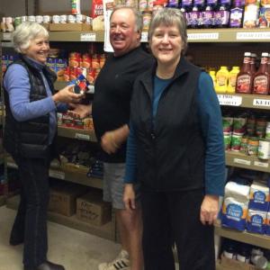 Volunteers, from left, Betsy Wing, Tom Wilson and Cindy Holton stock the shelves at the Food Pantry for the weekly opening. Courtesy of Helen Meserve Pantry