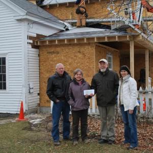 Friends of the Library volunteers, from left, treasurer Duane Dunbar and president Ann Kelley, present a check for $30,000 to Boothbay Harbor Memorial Library executive director Tim McFadden and Nicole Poulton, president of the Boothbay Harbor Memorial Library board of trustees, as construction on the addition to the library continues. Courtesy of Ann Kelley Library