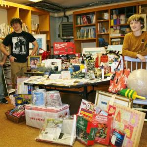 Southport Central School sixth graders, from left, Clarence Burnham, Ryan Hughes and Julius Bennett, stand amongst the myriad items they and others have collected for the Winter Carnival auction and raffle, which will be held at the Southport Town Hall on Saturday, March 22. KEVIN BURNHAM/Boothbay Register