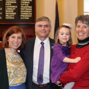 Senator Chris Johnson, recipient of the 1014 Frances Perkins Award for outstanding achievements, is shown with daughter Amanda (left), granddaughter Adelaide and wife Valarie at the Maine Senate Swearing-in Ceremonies, December 2012. Courtesy of Lincoln County Democrats