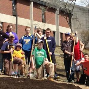 Volunteers working in the forest garden. From left, top row: Jessica Ganong, Allie Simmons, Xavier Downing, Zach Genrich, Nick Kilgus, Noah Sherburne, Draco Peaslee. Bottom row, from left: Bryan Dionne, Takoda Dionne, Riley Spear and (in the wheelbarrow) Nick Labonte. Courtesy of Bryan Dionne