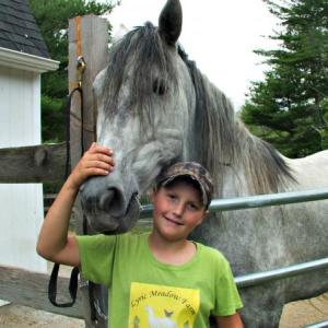 Young farmhand Wyatt Oakes with the largest horse, Necar, at Lyric Meadows Farm. KATRINA CLARK/Boothbay Register