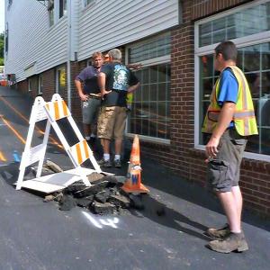 The alleyway between Coastal Maine Popcorn and A Silver Lining is marked with chalk and hazard signs as the Public Works crew figures out where the damage is. KATRINA CLARK/Boothbay Register