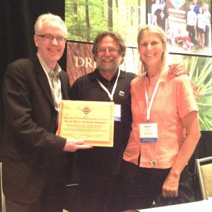 Hidden Valley Nature Center cofounders Tracy Moscovitz, center, and Bambi Jones, right, accept the North East Outstanding Tree Farm on the Year award from American Forest Foundation President Tom Martin. Courtesy of HVNC