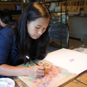 Lek Saruta, a “daughter” from the nonprofit Friends of Thai Daughters, creates an original woodblock print at Villard Studios. Courtesy of Julie Lamy