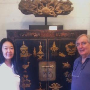Wurui and Michael Dunn stand in front of the recently acquired 18th century Chinese Scholar’s Cabinet. Courtesy of Jackie Sideli Wurui and Michael Dunn of Wiscasset, Maine and Bejing, China