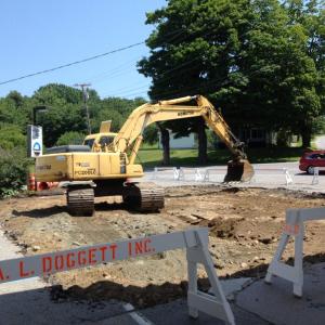 On July 8 a backhoe from A.L. Doggett digs up the north side of the station, where the new fuel tanks will be placed. KATRINA CLARK/Boothbay Register