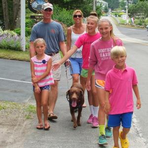 THE PENKIUNAS FAMILY, from Alexandria, Va., walks down Atlantic Avenue on July 3 from a house they are renting. From front left are: Lydia, Algis, Kathy, Anna, Mia, and Lydia’s twin brother, Kaz. And that’s Oliver in the middle. The Penkiunases have been coming to the harbor for visits for 15 years. SUZI THAYER/Boothbay Register