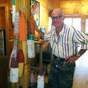 GENE DAMON, one of the owners of the new shop, Nauticalia, with some of his old wooden buoys. SUZI THAYER/Boothbay Register