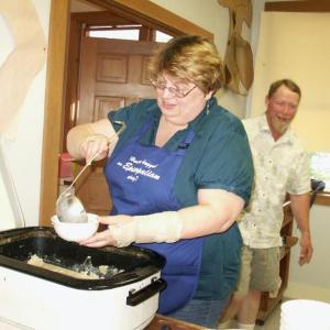 Cathy Tyler dishes out bowls of chowder at a July 2013 chowder supper at St. Philip’s Church, with Tim Cowing in the background. The church recently announced it is ending its long-running community chowder suppers. Courtesy of Gretchen Johnson