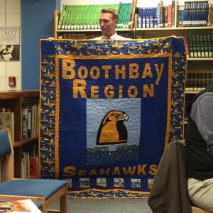 Dan Welch shows off the quilt made by his mother, Lynn Welch, at the Jan. 28 CSD School Committee meeting. KATRINA CLARK/Boothbay Register