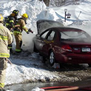 Boothbay firefighters spray water into a red Ford Taurus to extinguish a Feb. 11 car fire. KATRINA CLARK/Boothbay Register