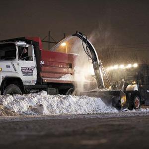 A Bobcat (of the type the Boothbay Harbor selectmen are purchasing for the town’s public works department), blows snow into a large truck. Courtesy of www.bobcat.com