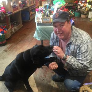 Don Kingsbury gives a treat to his oldest black lab, Coal, at Two Salty Dogs Pet Outfitters. KATRINA CLARK/Boothbay Register