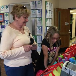 Suzanne “Nana” Shields, left, pays for books for her grandchildren at the book fair. On her right is Megan Leeman. Not pictured: Cassidy Leeman. KATRINA CLARK/Boothbay Register