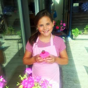 Elizabeth Szele holds one of her strawberry cupcakes that she will sell to benefit those in need. SUZI THAYER/Boothbay Register