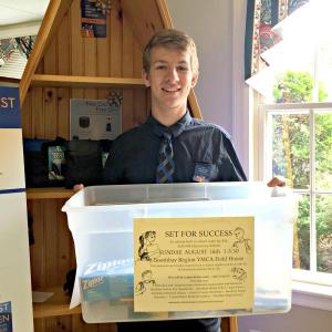 Bank teller David Machon (Boothbay Region High School class of 2015) of The First Bank holds the donation bin for Set for Success. KATRINA CLARK/Boothbay Register