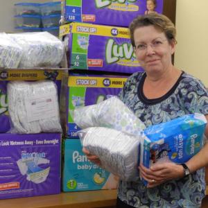 Ellen Baker, Early Head Start Home Visitor, picks up diapers collected at a Diaper Drive to distribute to local families experiencing diaper need. Courtesy photo