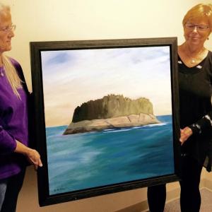 In honor of the work done by hospice teams, volunteer Sarah Rodgers, left, accepts a donation of artwork from artist Sarah Wilde, right. Courtesy of Alan Crowell