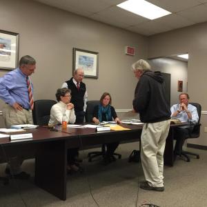 Bill Royall of Southport (in front of table) discusses possible plans with the Boothbay Harbor Board of Selectmen and Town Manager Tom Woodin. From left are Russ Hoffman, Denise Griffin, Bill Hamblen, Tricia Warren, Royall and Woodin. KATRINA CLARK/Boothbay Register