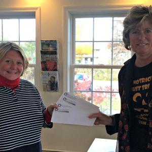 The First Branch Manager Brenda Blackman, right, buys four “Chamber Checks” from Michelle Davis for a gift basket being given away at the “Fang-tastic Free Checking Event” held from 7 a.m. to 7 p.m. on Friday, Oct. 30 at the First in Boothbay Harbor. KATRINA CLARK/Boothbay Register