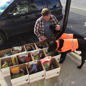 Two Salty Dogs owner Don Kingsbury with shop mascots Auggie and Max and the 12 large boxes of donations being sent overseas. KATRINA CLARK/Boothbay Register