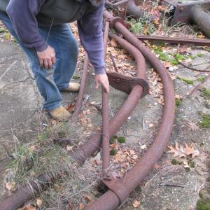 Steve Christiansen, a member of the Wiscasset town crew, examines an iron davit from the Luther Little once used to lower and hoist a lifeboat. PHIL DI VECE/Wiscasset Newspaper davit