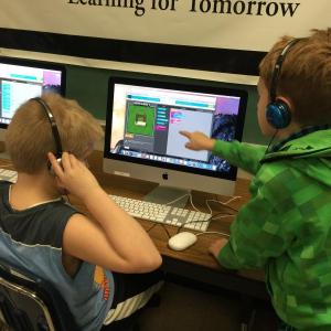 Fourth-grader C.J. Savastano, right, points out a missing piece of code to classmate Gabe Hackett, left, to help him complete a level in “Minecraft” during Hour of Code. KATRINA CLARK/Boothbay Register