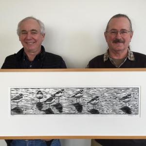 A member of the Midcoast Conservancy, left, and artist Jonathan Alderfer with one of Alderfer’s woodblock prints in his exhibition at the Conservancy in Wiscasset. Courtesy photo
