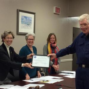 Palmer Payne, right, receives his surprise award from Board Chairman Denise Griffin, left, while selectmen Wendy Wolf (center left) and Tricia Warren (center right) look on. KATRINA CLARK/Boothbay Register