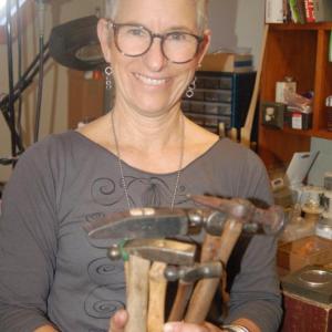Anita Roelz holds antique hammers she uses to fashion silver jewelry. ART MAYERS/Boothbay Register
