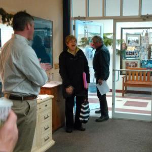 Boothbay Town Manager Dan Bryer Jr., left, and Southport Selectman Gerry Gamage welcome a surprised Jane Good to her “thank you” party. JANE CARPENTER/Boothbay Register