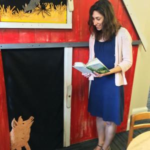 Desiree Scorcia, the new youth services librarian at the Boothbay Harbor Memorial Library, plans to read the classic Nancy Drew series to kids. Here, she has Wilbur of “Charlotte’s Web” entranced with one of the books. SUZI THAYER/Boothbay Register