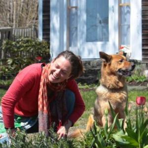 Boothbay Harbor-based massage therapist and herbalist Anna Christina Rogers outside her home with dog Kola. Courtesy of Robert Mitchell