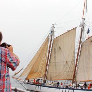 Micheal Leonard takes a shot of a Windjammer as it makes its way into Boothbay Harbor on June 29. SUZI THAYER/Boothbay Register