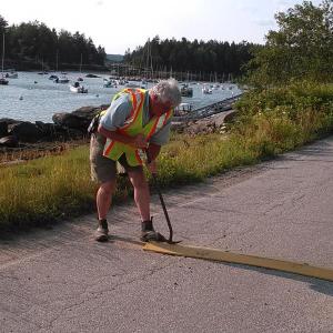 Selectman and Fire Chief Gerry Gamage removes speed bumps on Pratt’s Island Road in response to a neighborhood petition. JANE CARPENTER/Boothbay Register