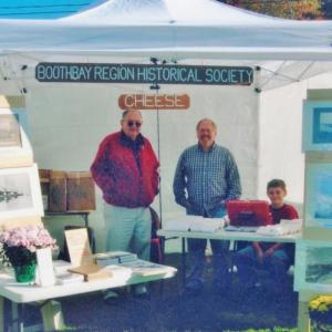 Look for the Boothbay Region Historical Society table at this year's Fall Foliage Festival. Here, from left, Ron Spofford, John McKown and Jared Spofford, man the BRHS cheese booth a few years back. Courtesy photo