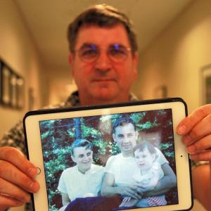 Bristol film maker Russell Lane Jr., holding a photo of his mother, father and older sister. Lane has made a movie about his parents’ role in the 1958 rescue of a boat of campers off Whitehead Island, where his father, Russell Lane Sr., was a lighthouse keeper. He will show the movie and give a short talk at Schooner Cove on Oct. 21 at 1:30 p.m. Courtesy of LincolnHealth