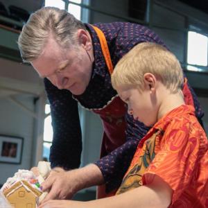 Kevin Kiley helps a young gingerbread engineer. DIANE DORBIN/Boothbay Register Kevin Kiley Gingerbread Opera House