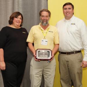Captain Bruce White, center, accepts Sea Tow’s “Rookie of the Year” award from Sea Tow President Kristen Frohnhoefer, left, and Captain Joseph Frohnhoefer III, Sea Tow chief executive officer, on Nov. 17 in Florida.