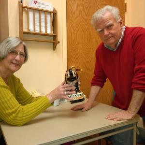 At the Community Center earlier this year, Richard Plunkett examines an item belonging to Nancy Conley. JANE CARPENTER/Boothbay Register