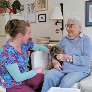 Assisted Living staff member Bridy Lewis, CRMA/CNA, visiting resident Charlotte Gowen and her companion Cokie. Courtesy photo