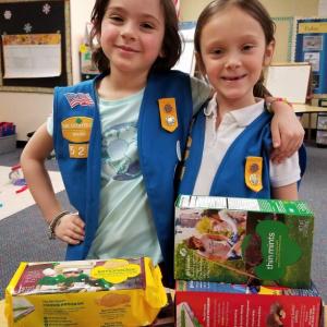 Girl Scout Daisies Gigi Blake (left) and Olivia Carlson of Troop 526 hold up some cookie favorites. Courtesy of Tonia Blake