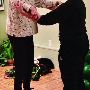 Boothbay Region Health Care’s “Fit, Flexible and Strong” program participant, Mary Hull, does a balance exercise with a little help from wellness coach Mary Baudo. Courtesy of Robert Crink