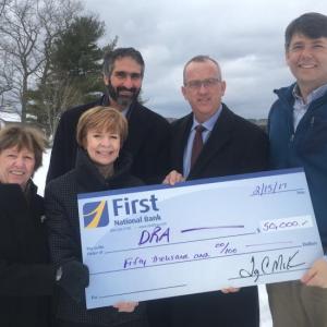 First National Bank presents Damariscotta River Association with a check at DRA Round Top Farm in support of DRA’s capital campaign to enhance education programs, conserve special lands, and protect water quality. Pictured from the left are Emily MacKenzie, DRA leadership gifts chair and former board president; Susan Norton, First National Bank executive vice president and chief administrative officer; Gary Stone, First Advisors vice president and portfolio manager, Tony McKim, First National Bank president and CEO, and Steven Hufnagel, DRA executive director. Courtesy photo