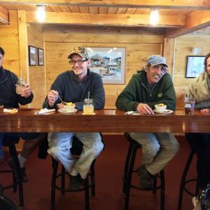 Jason Harvey, left, Bill Little and Dave Burnham sit at the small bar they built, with Robinson’s owner Kellie Slater. SUZI THAYER/Boothbay Register