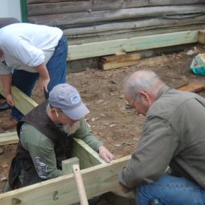 House captain Chris Higgins, left, lines up a a deck support for volunteers Rick Green and Alan Miller. ART MAYERS/Boothbay Register