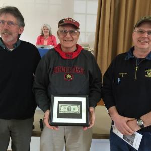Edgecomb Selectman Mike Smith, left, and Fire Chief Roy Potter, right, present the last Edgecomb Fire Company chief, Tom Trowbridge, with a two dollar bill prior to the May 13 town meeting. BILL PEARSON/Boothbay Register