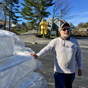 Tim Brown of Brown’s Wharf stands in the parking lot next to some of the new mattresses that will replace the ones given away May 4. SUZI THAYER/Boothbay Register